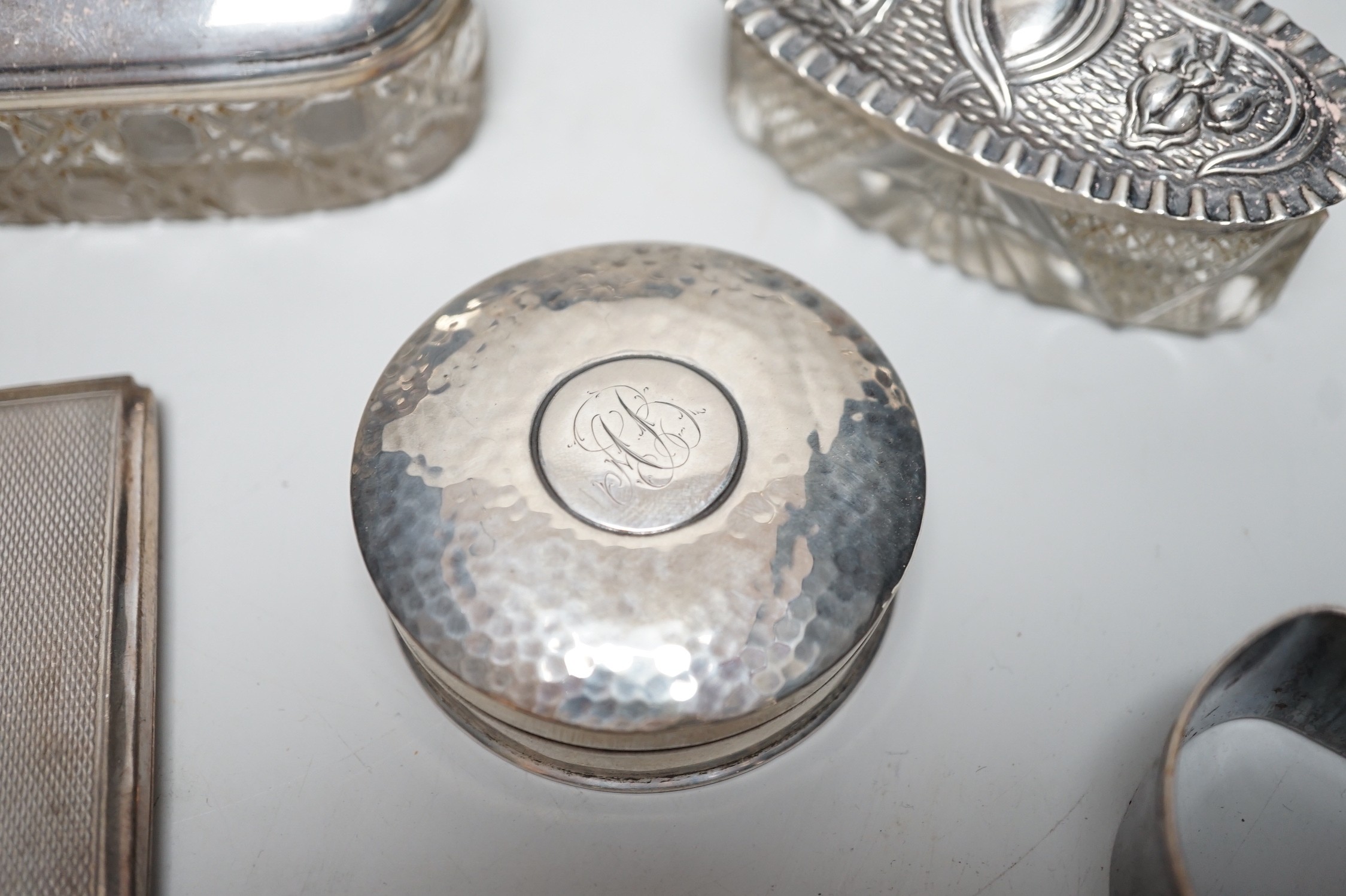 Sundry silver items, including a 1930's silver presentation cup, height 10.9cm, five silver or white metal mounted glass toilet jars, two silver napkin rings, two compacts, silver flatware and two Chinese white metal nap